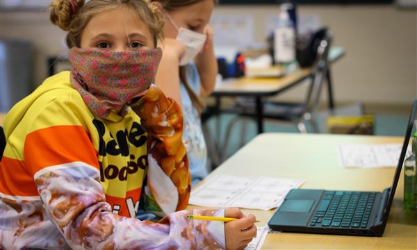 Girl smiles while wearing mask